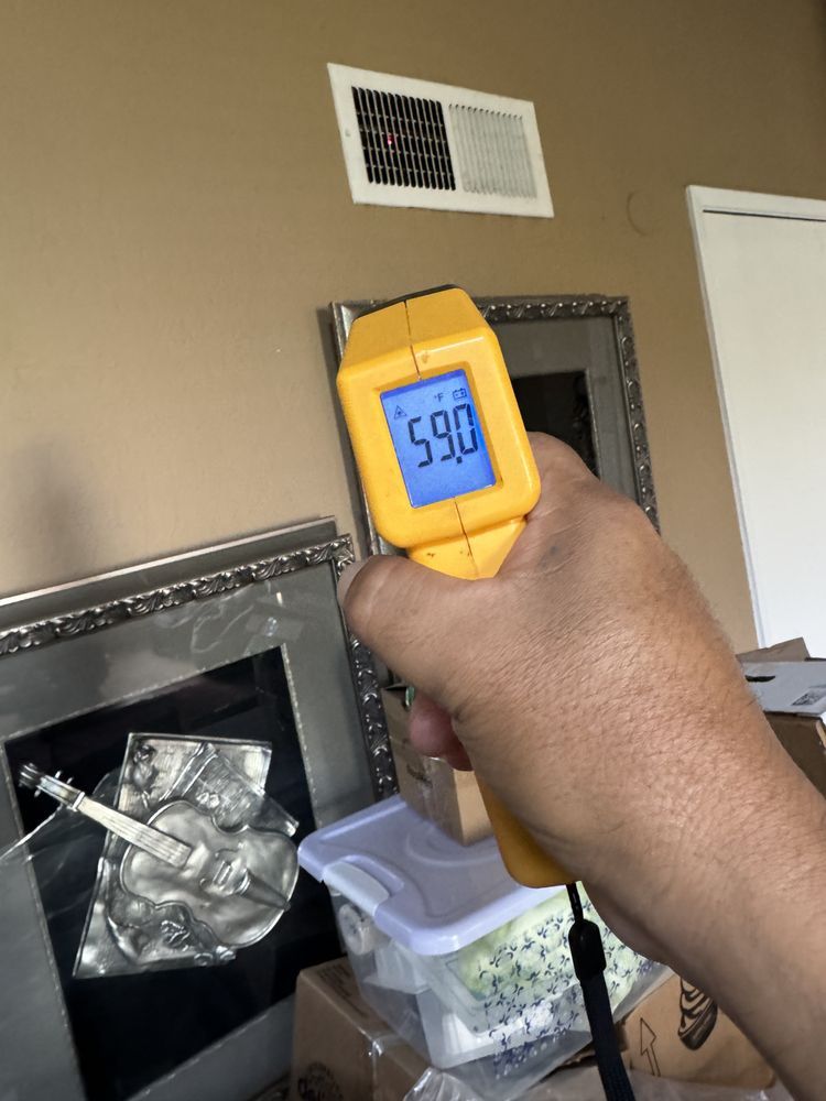 Infrared thermometer reading a vent temperature during a diagnosis